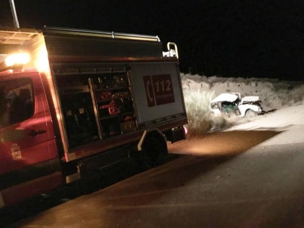 Un camión de bomberos de Baza cerca del vehículo donde viajaban los dos fallecidos./IDEAL