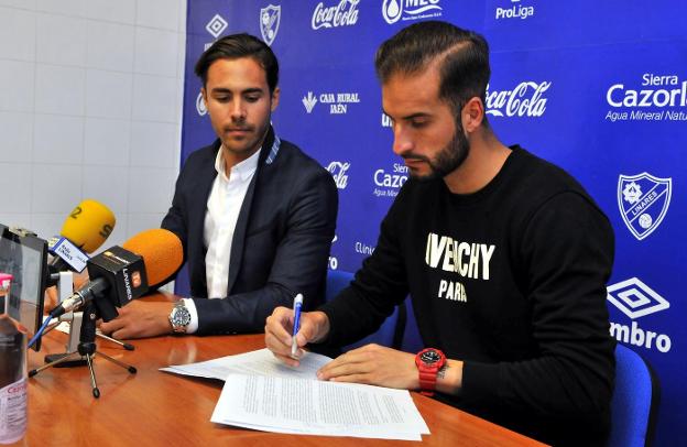 Miguel Linares observa como Josema firma su renovación por el Linares hasta 2020./ENRIQUE