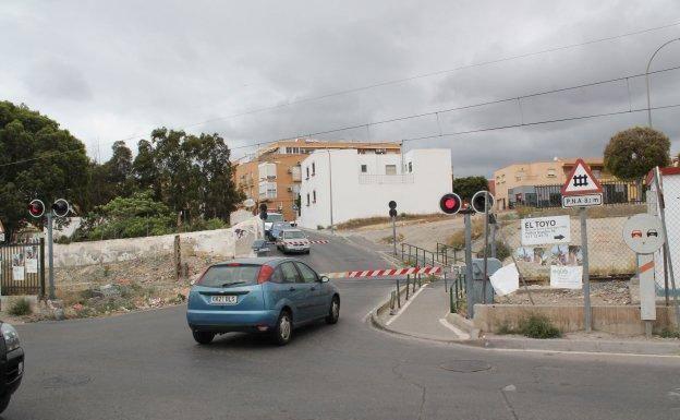 Un coche espera a que suba la barrera del paso a nivel.
