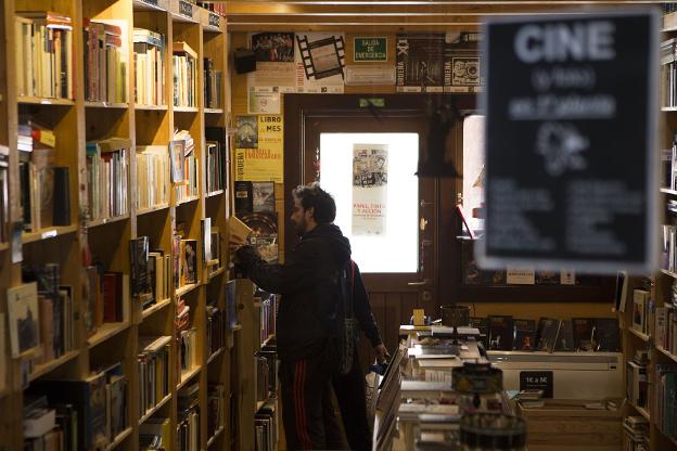 Un joven bucea en la estantería de una librería./VIRGINIA CARRASCO