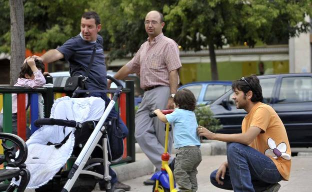 Padres juegan con sus hijos en un parque./J. V. Arnelas