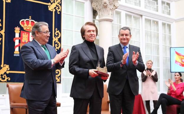 Raphael recibiendo el premio esta mañana flanqueado por el ministro Juan Ignacio Zoido y el delegado del Gobierno en Andalucía, Antonio Sanz./DELEGACIÓN DEL GOBIERNO