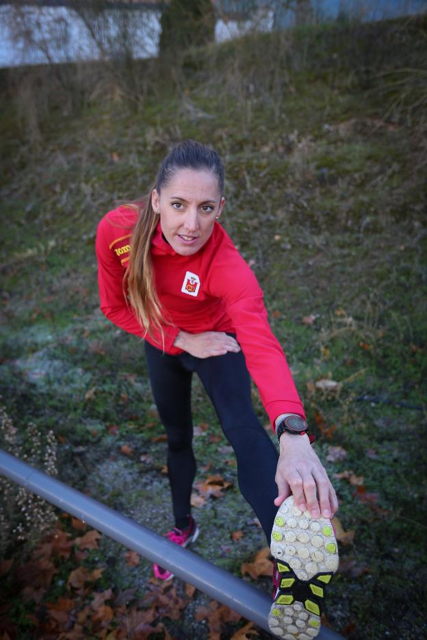 Ainhoa Pinedo estira en la pista de atletismo de Maracena tras un entrenamiento./RAMÓN L. PÉREZ