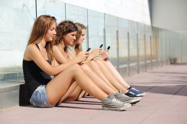 Adolescentes consultan sus teléfonos. /IDEAL
