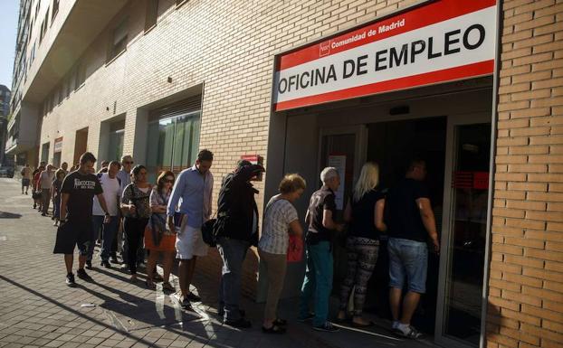 Numerosas personas esperan para entrar a una oficina de empleo en Madrid./REUTERS