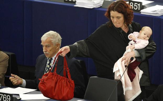 Una europarlamentaria danesa vota en una sesión del Parlamento Europeo mientras vigila a su bebé. /Vincent Kessler (Reuters)