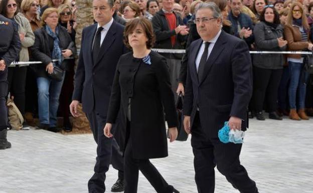 Imágenes de Zoido en el funeral del niño Gabriel con la bufanda en la mano./EFE