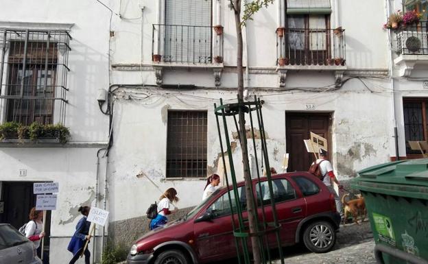 Los familiares, pancarta en mano, suben la Cuesta de Alhacaba hacia su vivienda para expulsar a los okupas, el jueves pasado./JAVIER F. BARRERA