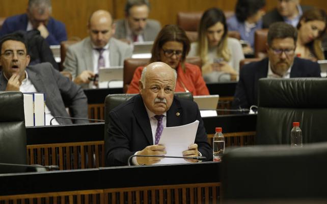 El consejero de Salud, Jesús Aguirre, sentado en su escaño delante de la bancada socialista, con su portavoz, Mario Jiménez, detrás./EP