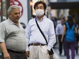 Un turista porta una mascarilla para protegerse de un posible contagio de la gripe AH1N1 mientras pase por una calle del centro de Málaga. / Efe/