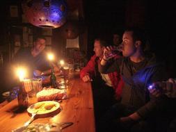 Los clientes de un bar se iluminan con velas durante el corte de luz. GONZÁLEZ MOLERO/
