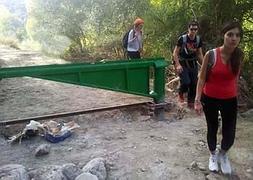 Un grupo de senderistas camina junto a una de las barreras. :: SACROMONTE MÁS VERDE/