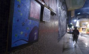 Un transeúnte pasa delante de un cuadro colgado en la fachada del antiguo cine Coliseo Viñas./